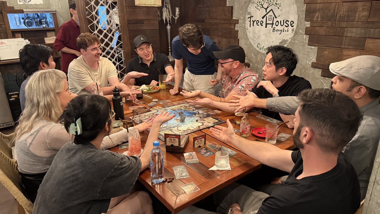 Guests leaning in over a game at Game Night